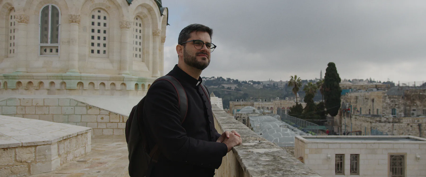 Sacerdote diante da paisagem de Jerusalém